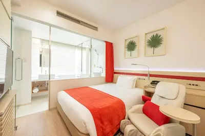 a bedroom with a bed and a desk and a chair at remm Akihabara in Tokyo