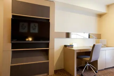 a room with a desk and a tv and a desk and a chair at Hotel Sardonyx Tokyo in Tokyo
