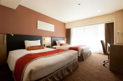 a hotel room with two beds and a desk at Hotel Sardonyx Tokyo in Tokyo
