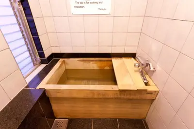 a bath tub in a bathroom with a sink at Kimi Ryokan in Tokyo