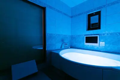 a blue bathroom with a tub and a sink at HOTEL PERRIER (Adult Only) in Tokyo