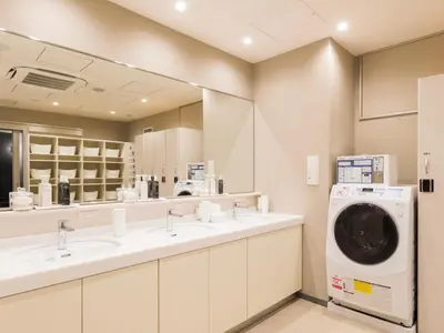 a bathroom with two sinks and a washing machine at Glansit Akihabara in Tokyo
