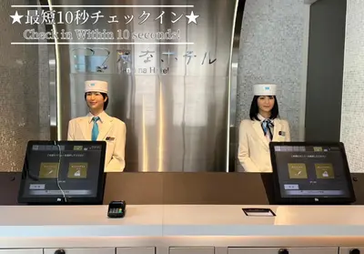 a man and a woman standing in front of a mirror at Henn na Hotel Tokyo Hamamatsucho in Tokyo