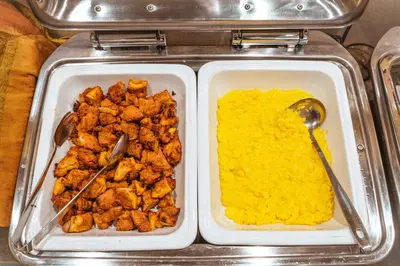two trays of food with chicken and yellow sauce at Henn na Hotel Tokyo Asakusabashi in Tokyo