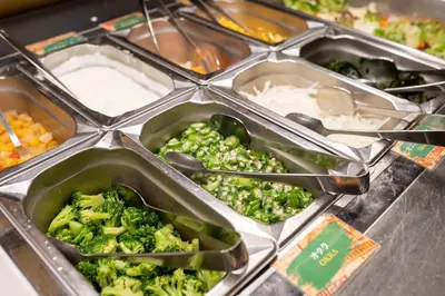 a bunch of trays of broccoli and other food at Henn na Hotel Tokyo Asakusabashi in Tokyo