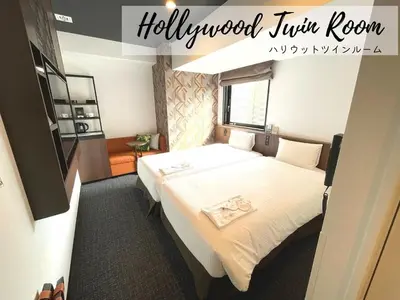 a hotel room with a bed and a sign that reads hollywood twin room at Henn na Hotel Tokyo Akasaka in Tokyo