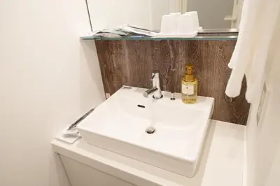 a bathroom with a white sink and a mirror at Henn na Hotel Tokyo Akasaka in Tokyo