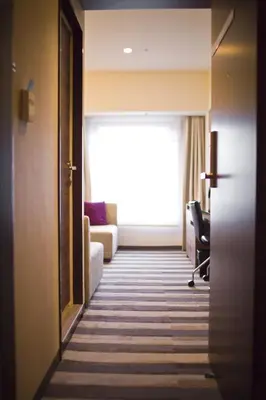 a hallway of a hotel room with a couch and a window at Tokyo Green Palace in Tokyo