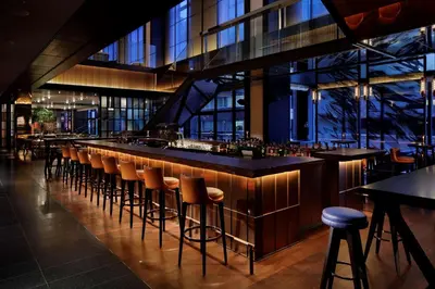 a bar with brown stools in a restaurant at Hyatt Centric Ginza Tokyo in Tokyo