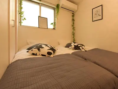two beds in a small room with a window at THE HOUSE Ikebukuro Sugamo in Tokyo