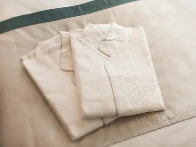 a pair of white pants sitting on a bed at Tosei Hotel Cocone Kanda in Tokyo