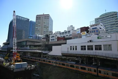 a train is parked at a train station in a city at Tosei Hotel Cocone Kanda in Tokyo