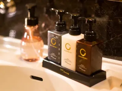 two bottles of soap andodorizers sitting on a bathroom sink at Tosei Hotel Cocone Kanda in Tokyo