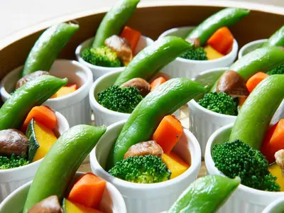 a tray of carrots broccoli and other vegetables in cups at Hotel Intergate Tokyo Kyobashi in Tokyo