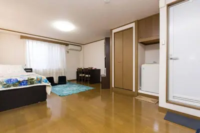 a bedroom with a bed and a room with a kitchen at Shinjuku Central Apartment 203 in Tokyo