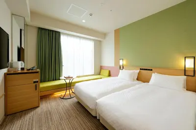 a hotel room with two beds and a window at Candeo Hotels Tokyo Shimbashi in Tokyo