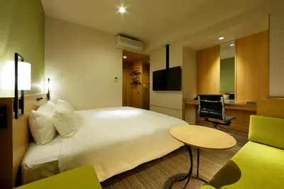a hotel room with a large bed and a desk at Candeo Hotels Tokyo Shimbashi in Tokyo