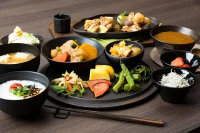 a table topped with different types of food on plates at Candeo Hotels Tokyo Shimbashi in Tokyo