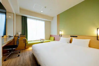 a hotel room with a large bed and a television at Candeo Hotels Tokyo Shimbashi in Tokyo