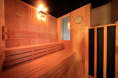 a wooden sauna with a clock on the wall at Candeo Hotels Tokyo Shimbashi in Tokyo
