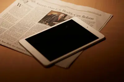 a cell phone sitting on top of a newspaper at Tokyo Prince Hotel in Tokyo