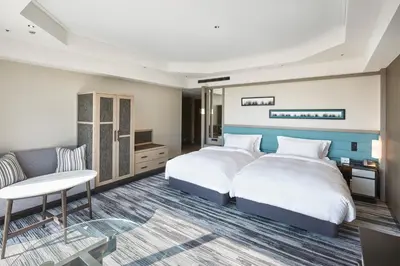 a hotel room with two beds and a couch at The Prince Park Tower Tokyo - Preferred Hotels & Resorts, LVX Collection in Tokyo