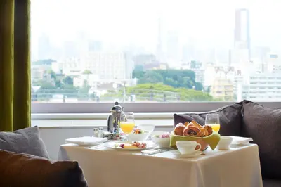 a table with a plate of food and drinks on it at The Prince Sakura Tower Tokyo, Autograph Collection in Tokyo