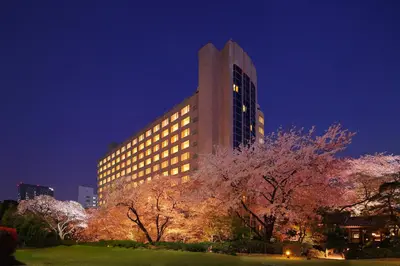 a tall building at night with trees in front of it at The Prince Sakura Tower Tokyo, Autograph Collection in Tokyo