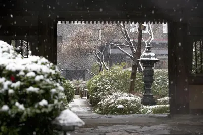 a snow covered garden with a light pole and bushes at Grand Prince Hotel Takanawa in Tokyo