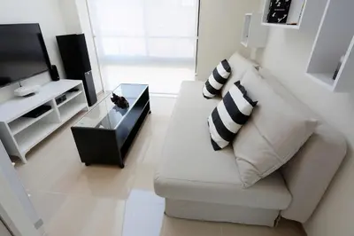 a white living room with a couch and a tv at La Krasse Sumida in Tokyo