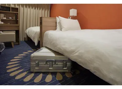 a suitcase sitting next to a bed in a hotel room at Sunshine City Prince Hotel Ikebukuro Tokyo in Tokyo