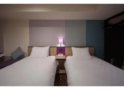 two beds in a room with a lamp between them at Sunshine City Prince Hotel Ikebukuro Tokyo in Tokyo