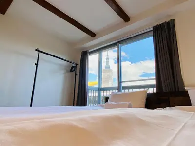 a bedroom with a bed and a large window at Hostel Chapter Two Tokyo in Tokyo