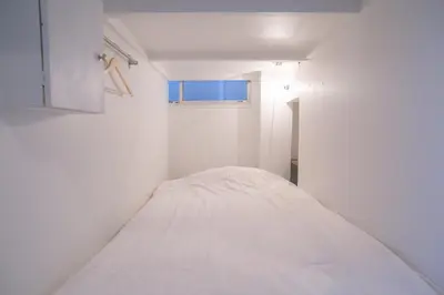 a white room with a bed in it at Hostel Chapter Two Tokyo in Tokyo