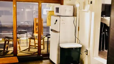 a white refrigerator with a microwave on top of it at Hostel Chapter Two Tokyo in Tokyo