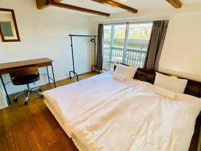 a bedroom with a bed with a desk and a window at Hostel Chapter Two Tokyo in Tokyo