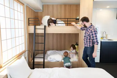 a man and two children standing next to bunk beds at MIMARU Tokyo Ueno North in Tokyo