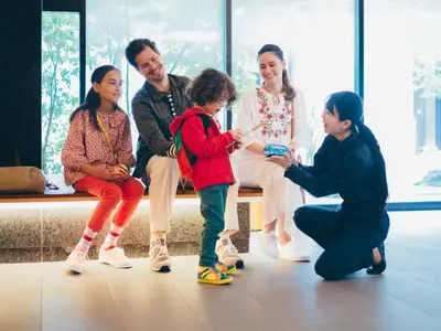 a group of people sitting on a bench playing with a child at MIMARU Tokyo Ueno North in Tokyo