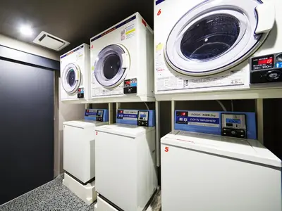 a laundry room with three washing machines and a washer and dryer at MIMARU Tokyo Ueno North in Tokyo