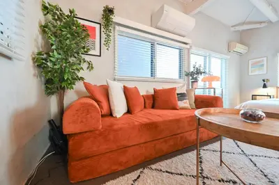 a living room with a orange couch and a table at 846 apartment in Tokyo
