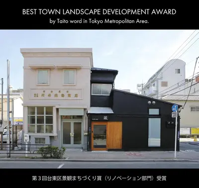 a black and white building on a city street at Hostel Kura in Tokyo
