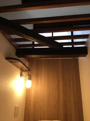 a room with a bed and a ceiling with a light at Hostel Kura in Tokyo