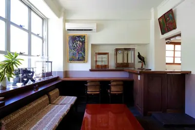 a bar with a bench in a room with windows at Hostel Kura in Tokyo