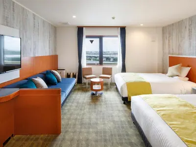 a hotel room with two beds and a couch at HOTEL MYSTAYS Maihama in Urayasu