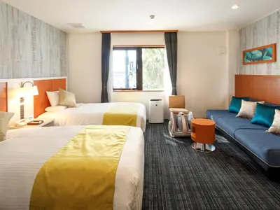 a hotel room with two beds and a couch at HOTEL MYSTAYS Maihama in Urayasu