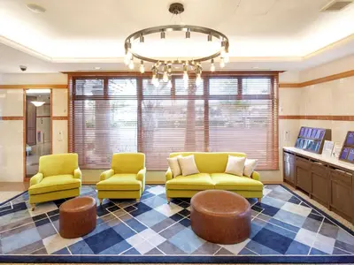 a waiting room with two yellow chairs and a chandelier at HOTEL MYSTAYS Maihama in Urayasu