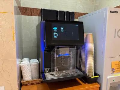 a coffee maker with a stack of cups and plates at HOTEL MYSTAYS Maihama in Urayasu