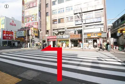 a crosswalk with a red arrow on a city street at Royal Hotel Shinokubo in Tokyo
