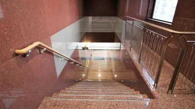a staircase in a building with a metal hand rail at Royal Hotel Shinokubo in Tokyo