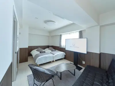 a room with two beds and a projection screen at Sakura Cross Hotel Ueno Iriya in Tokyo